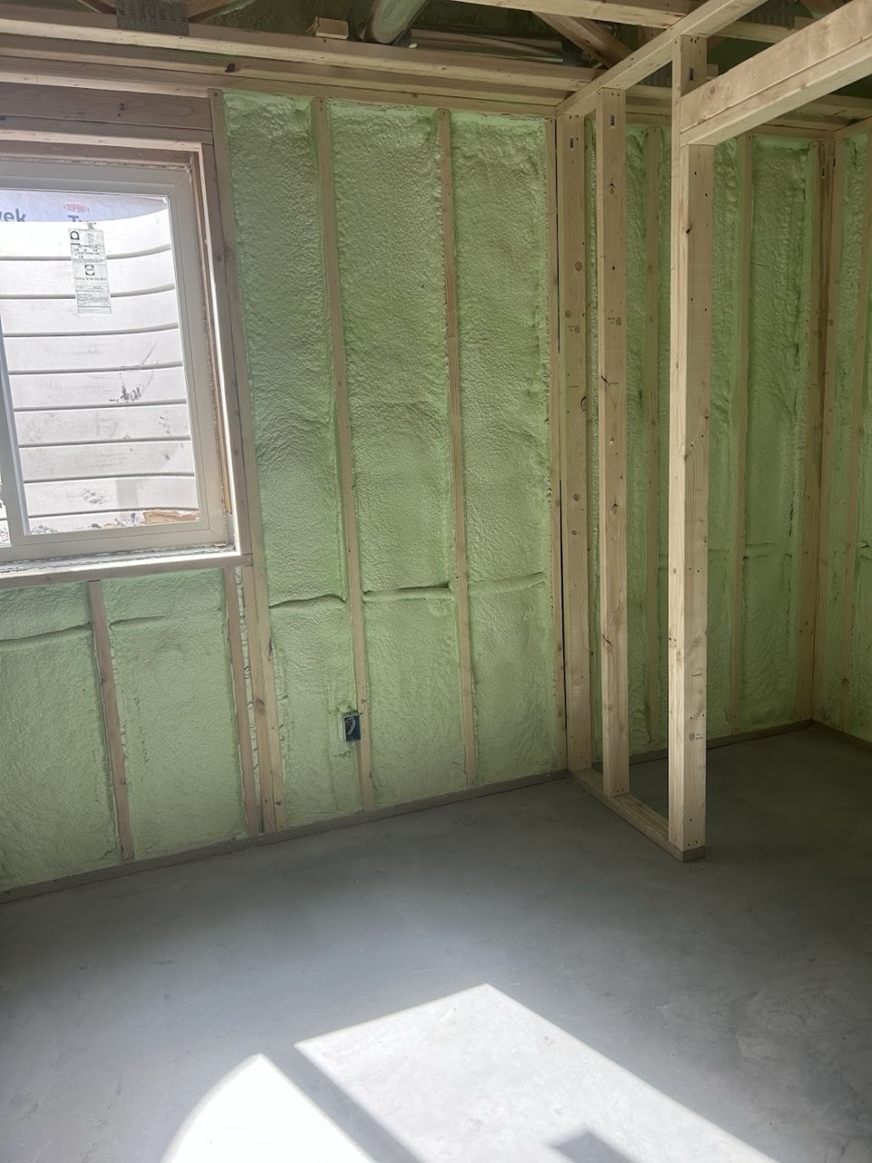 Green spray foam insulation Fargo applied to stud walls.