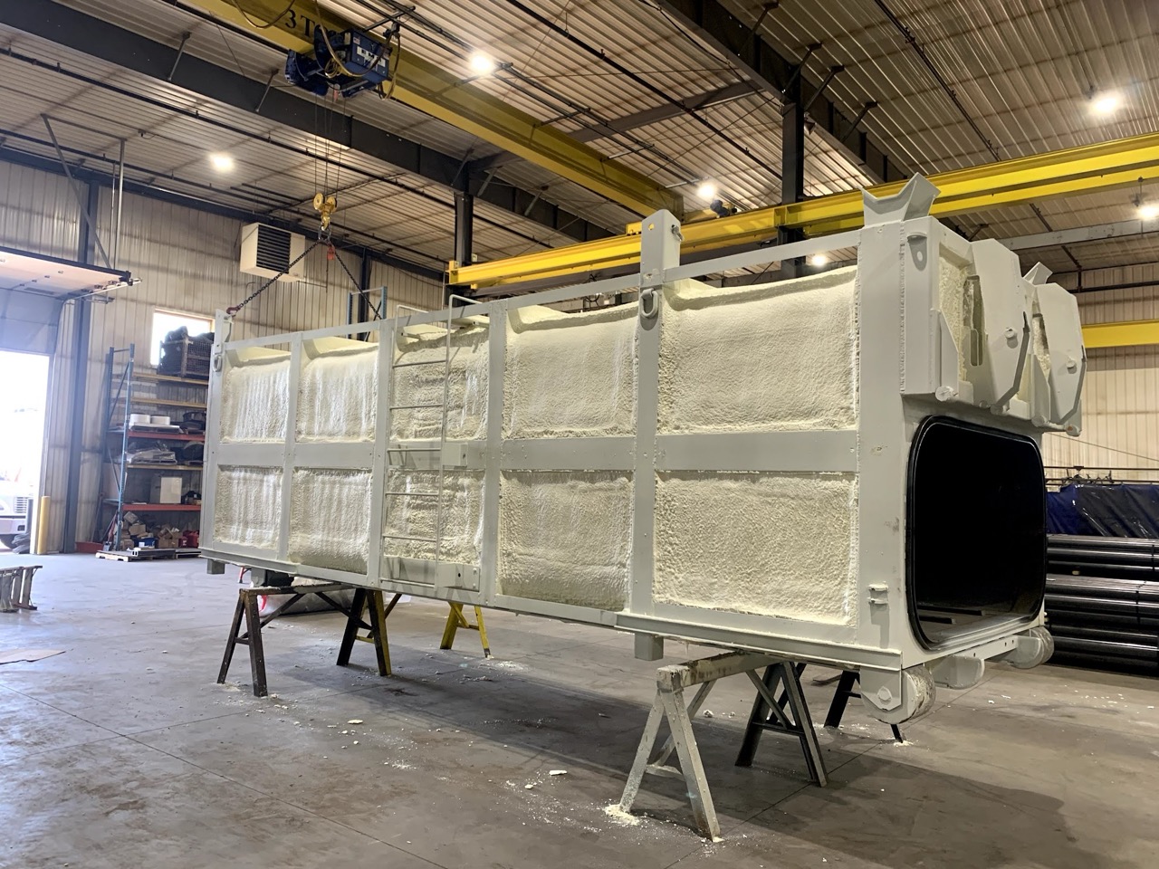 Large industrial equipment coated in spray foam insulation.